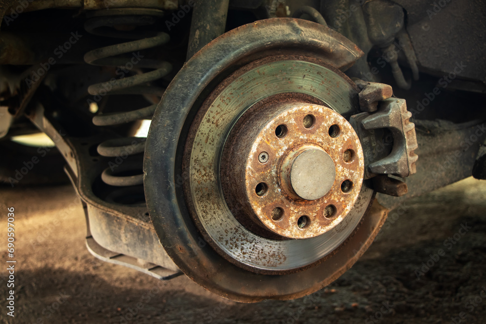 Rusty brake discs on an abandoned car. Object illuminated with soft, natural light Rusty brake discs on an abandoned car. Object illuminated with soft, natural light