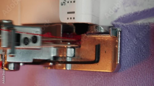 Details of sewing machine. Extreme close up of overlock machine. Vertical video photo