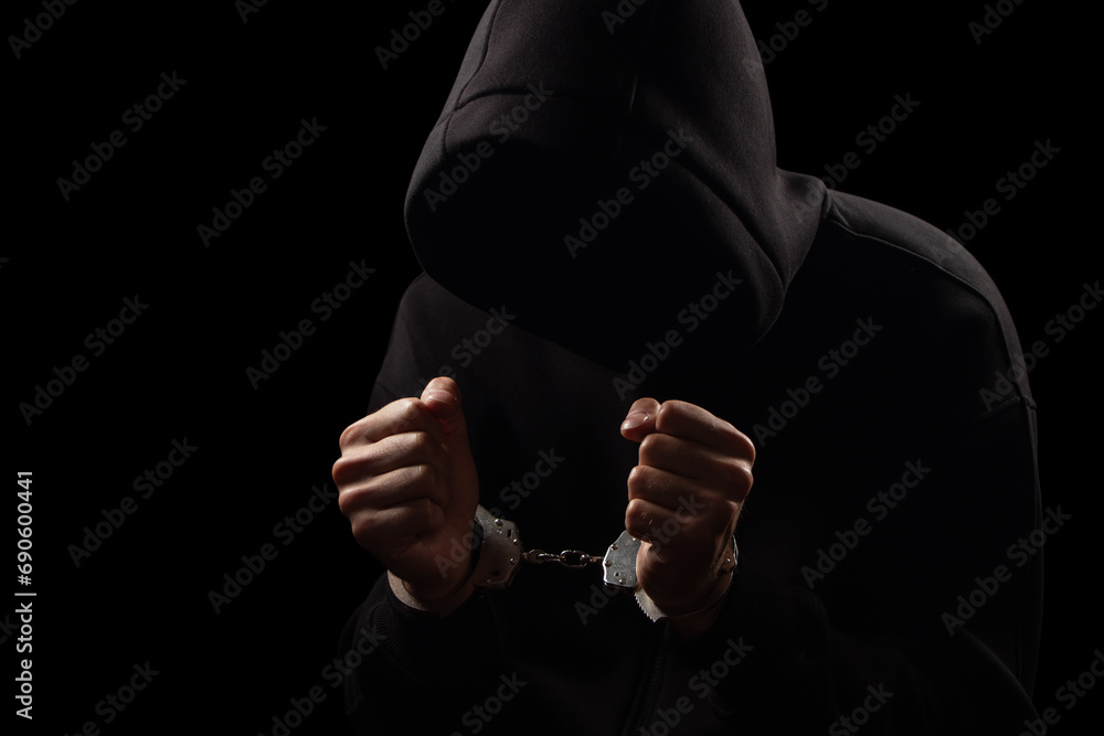 Silhouette of handcuffed male in hoodie, dangerous criminal punished by law.