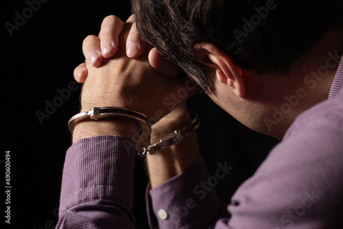 Businessman arrested for corruption. Man in a suit with handcuffs on his hands.