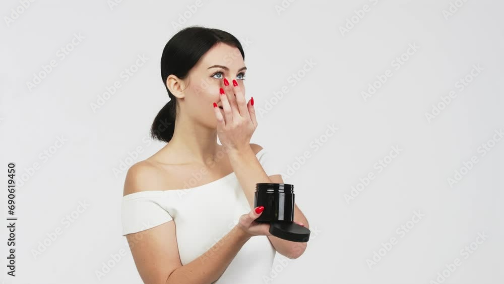 Portrait of a charismatic young woman using face creams. Concept of fresh moisturized skin, beautiful cosmetic face, happy healthy model. A young brunette takes care of her skin. Portrait of a charismatic young woman using face creams. Concept of fresh moisturized skin, beautiful cosmetic face, happy healthy model. A young brunette takes care of her skin.