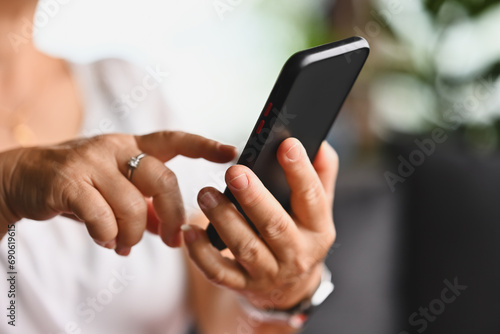 Close-up with mature adult woman hands using smartphone