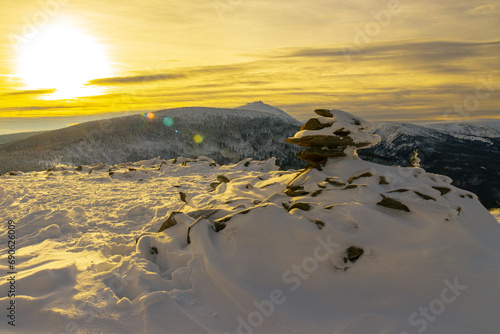 Zimowy krajobraz w Karkonoszach o zachodzie słońca, na Skalnym Stole z widokiem na Śnieżkę