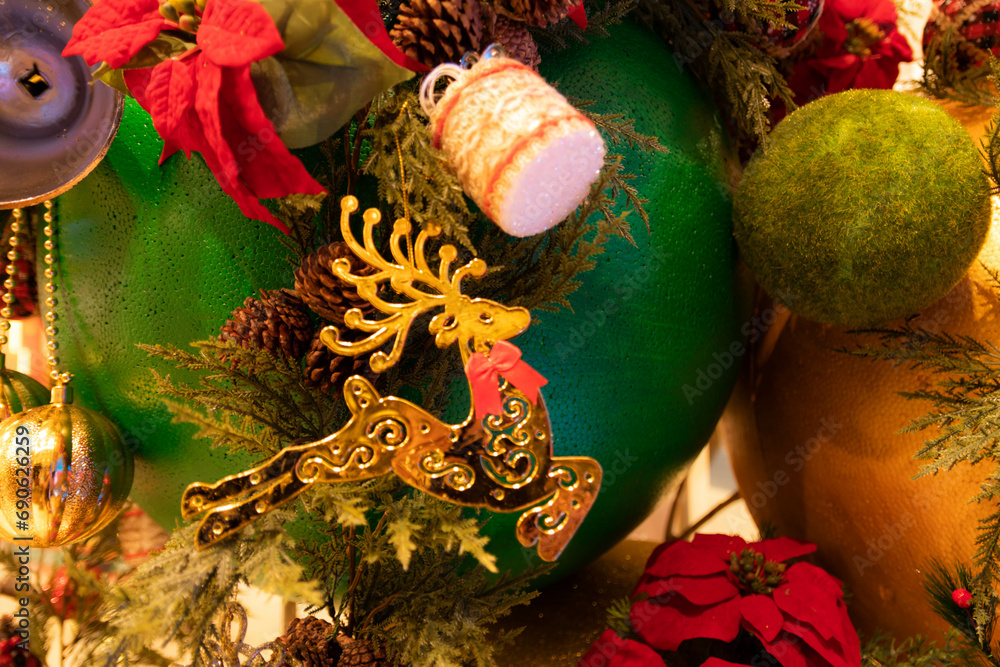 Naklejka premium Christmas decoration with reindeer, a dried pine cone, ball, leaf, branch. Christmas background. Christmastime celebration.