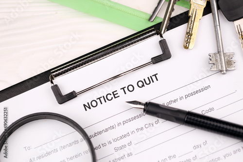 Notice to quit or eviction notice blank on A4 tablet lies on office table with pen and magnifying glass close up