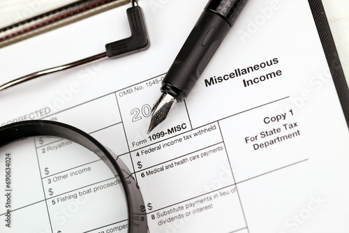IRS Form 1099-misc Miscellaneous income blank on A4 tablet lies on office table with pen and magnifying glass close up