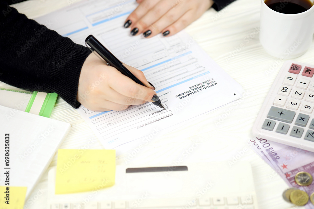 Accountant fill italian tax form F23 Payment model taxes duties penalties and other revenues in end of tax period. Taxation and paperwork routine in Italy Accountant fill italian tax form F23 Payment model taxes duties penalties and other revenues in end of tax period. Taxation and paperwork routine in Italy
