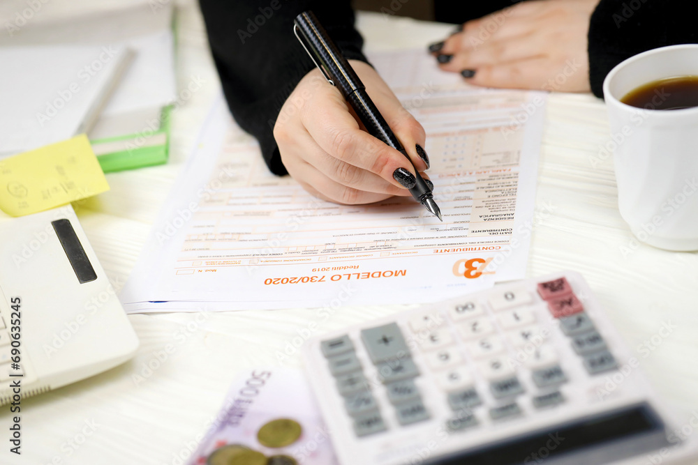 Accountant fill italian tax form Modello 730 individual income tax return in end of tax period. Taxation and paperwork routine in Italy Accountant fill italian tax form Modello 730 individual income tax return in end of tax period. Taxation and paperwork routine in Italy