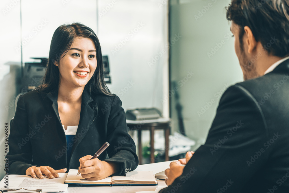 Businesswoman from human resources department is interviewing businessman candidate for job application in meeting room while considering his CV resume document. Employee hiring business concept. uds - obrazy, fototapety, plakaty 