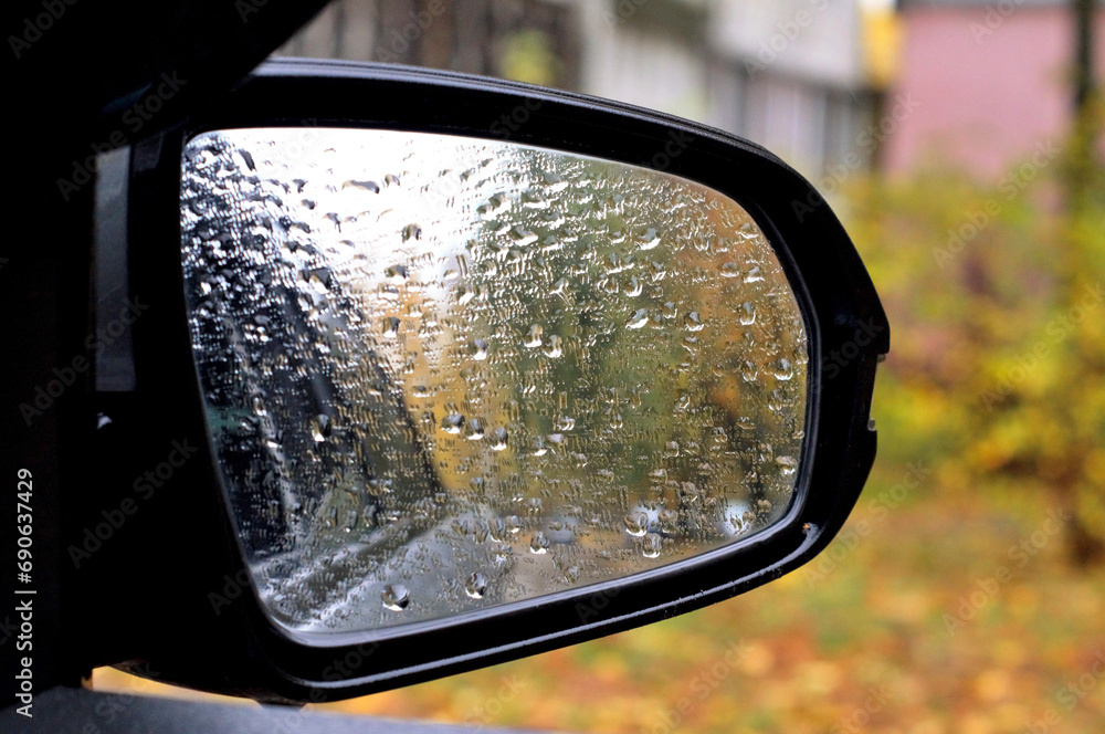 a side mirror of a modern car in raindrops a side mirror of a modern car in raindrops