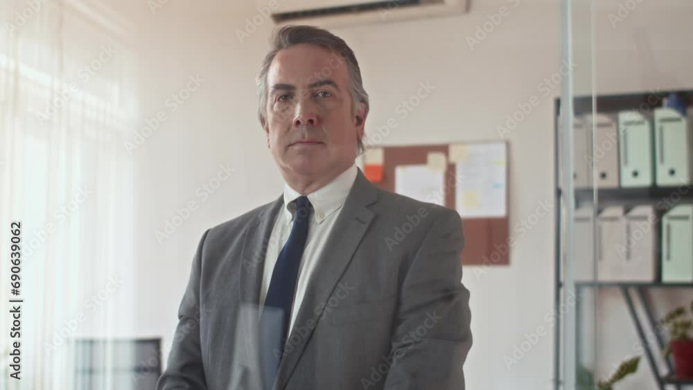 Medium portrait of elderly male entrepreneur in business suit working at office, looking at camera Medium portrait of elderly male entrepreneur in business suit working at office, looking at camera