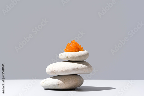 Fototapeta Naklejka Na Ścianę i Meble -  Caviar de salmón sobre piedras blancas. Comida gourmet sobre fondo gris