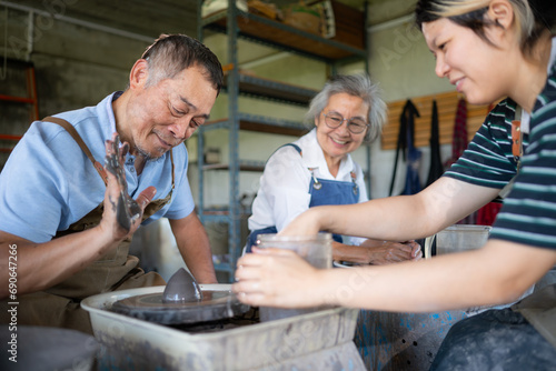 Portrait of a senior Asian couple doing activities together in the pottery workshop.