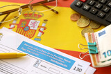 Modelo 130 spanish tax form for personal income tax for employers and professionals in direct evaluation instalments lies on flag of Spain close up on accountant table