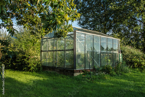 greenhouse with plants in a garden in the French village of Parfondeval © henkbouwers