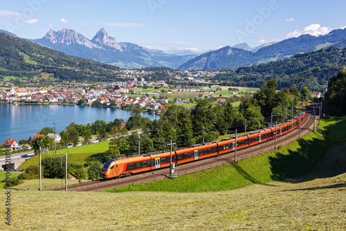 Passenger train type Stadler Flirt of Südostbahn at Grosser Mythen mountain at Lake Zug in the Swiss Alps in Arth, Switzerland