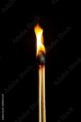 A matchstick against a dark surface isolated on white background 