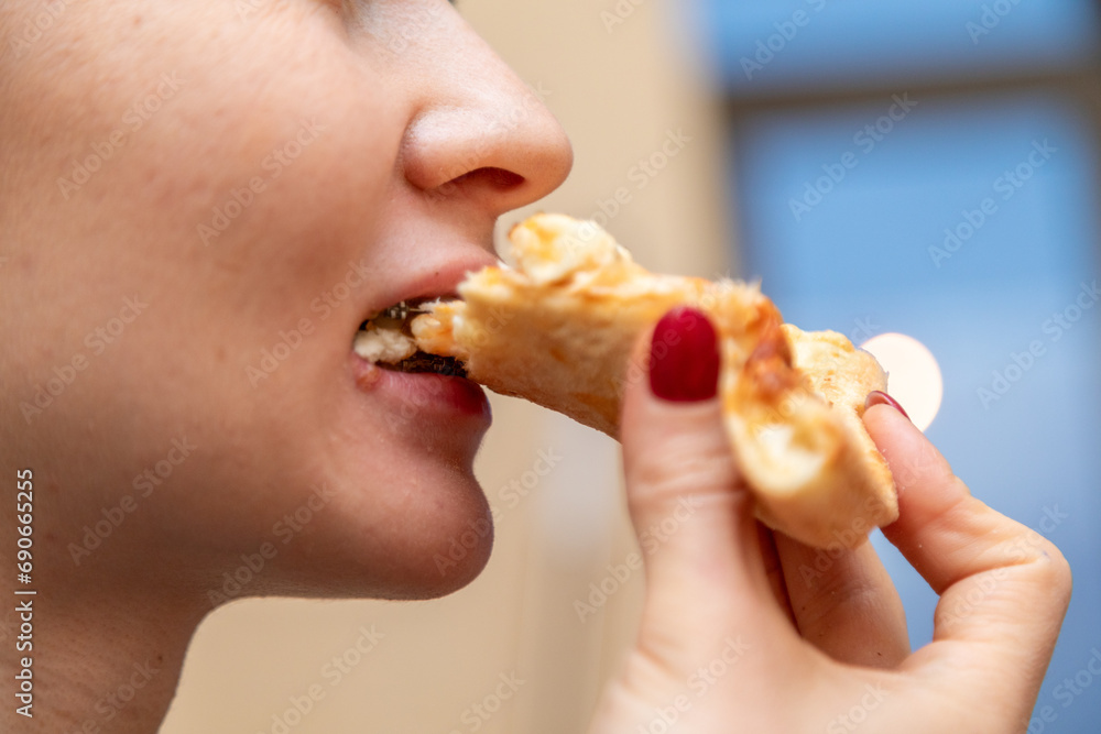 Closeup of woman with dental braces eating slice of pizza Closeup of woman with dental braces eating slice of pizza