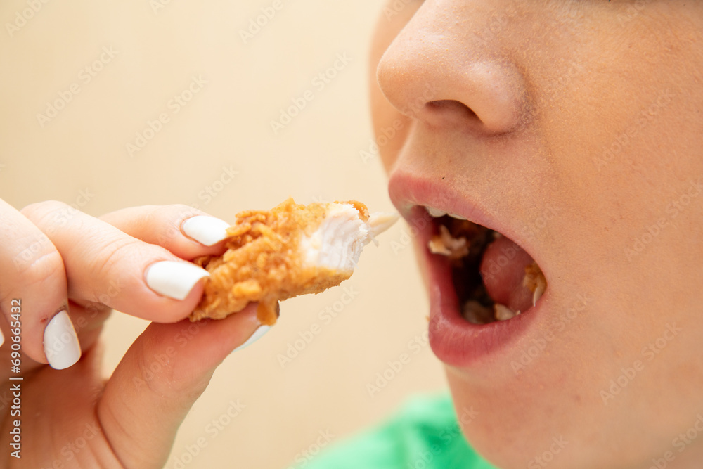 Closeup of woman eating chicken fillet