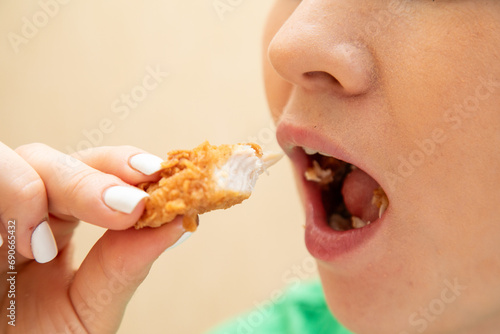 Closeup of woman eating chicken fillet © Collab Media