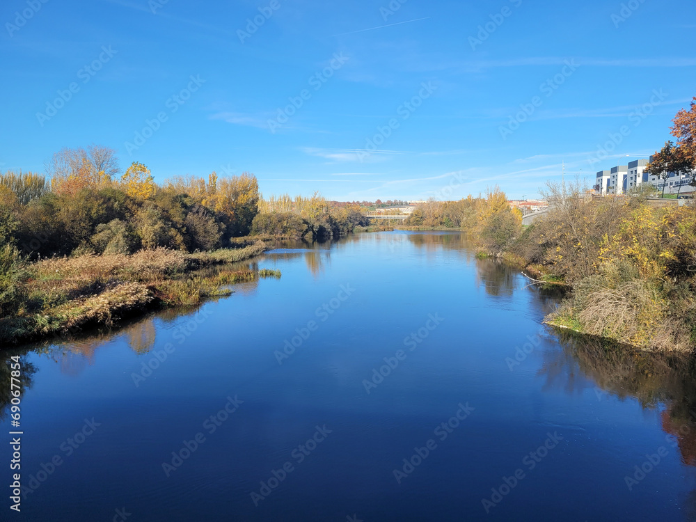 Blue waters of the Tormes River on a cold December morning, both banks can be seen, seen from the most modern bridge in the city Blue waters of the Tormes River on a cold December morning, both banks can be seen, seen from the most modern bridge in the city