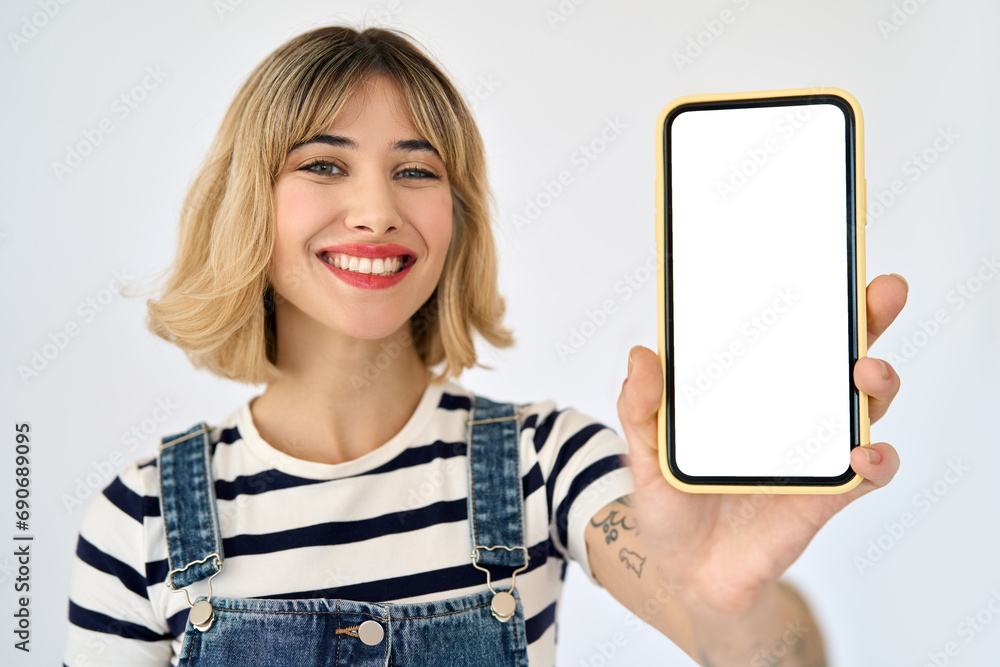 Happy young gen z blonde woman shopper girl student holding smartphone using mobile cell phone showing big mockup screen presenting shopping sale application on cellphone isolated on background. - obrazy, fototapety, plakaty 