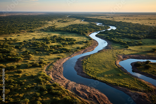A bird's-eye view shot from a drone, showcasing a winding river through the savanna