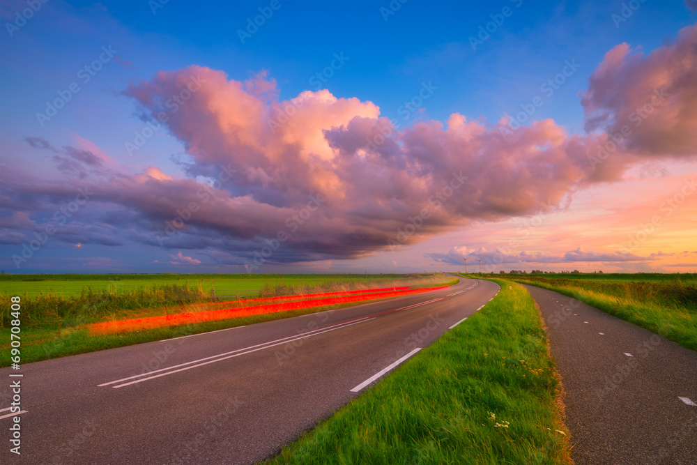 Landscape during sunset with road and clouds. A beautiful asphalt road with sky during sunset. Panoramic photo for design and background.
