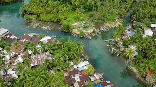 Panorama view of Bogac Cold Spring surrounded by tropical forest and fishermen houses. Surigao del Sur. Philippines. photo