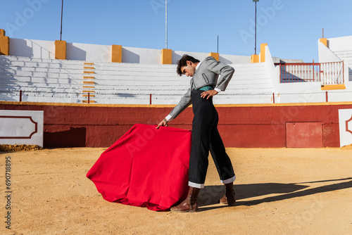 Hispanic bullfighter waving red cloth