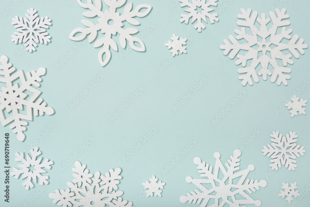 Festive frame made of wooden snowflakes on a blue background. Winter, Christmas, New Year concept. Festive frame made of wooden snowflakes on a blue background. Winter, Christmas, New Year concept.