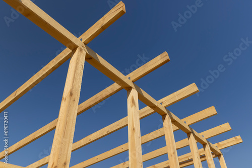 the wooden frame of the building against the blue sky