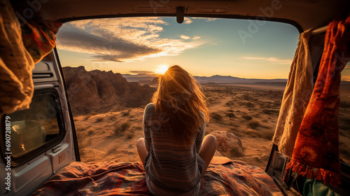 Back view of young woman sitting and enjoying beautiful view on camper van. Ttravel, holiday concept photo