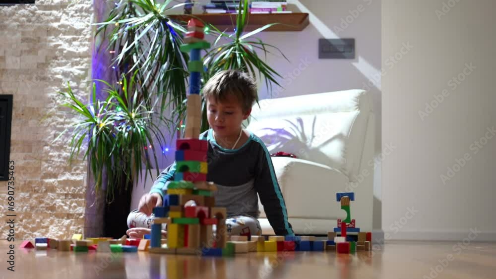 Focused boy building with wooden blocks on the floor, demonstrating hands-on learning and cognitive development in a home environment. Focused boy building with wooden blocks on the floor, demonstrating hands-on learning and cognitive development in a home environment.