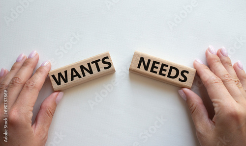 Wants and Needs symbol. Concept word Wants and Needs on wooden blocks. Businessman hand. Beautiful white background. Business and Wants and Needs concept. Copy space photo
