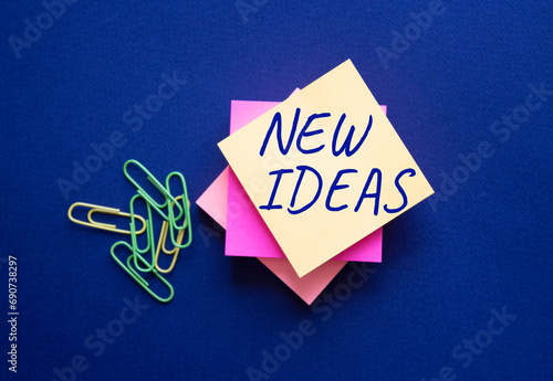 New ideas symbol. Orange steaky note with concept words New Ideas. Beautiful deep blue background. Business and New ideas concept. Copy space photo