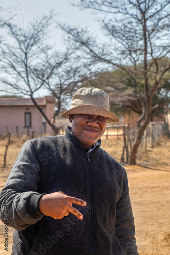 portrait of happy overweight village young man , victory gesture , Botswana rural area
