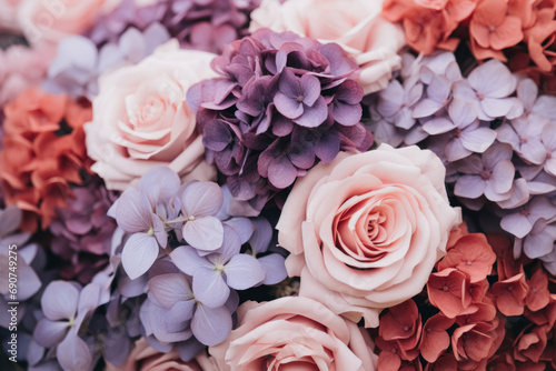 A close-up of a vibrant bouquet featuring soft pink roses and various shades of purple hydrangeas, presenting a rich floral texture.