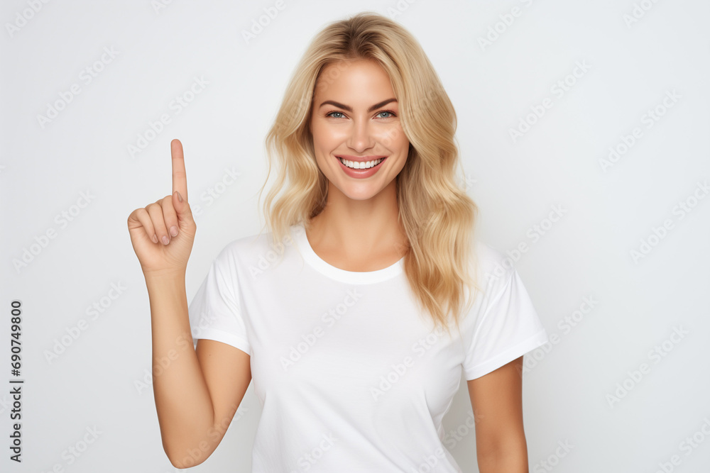 Portrait of happy young woman pointing finger up over white background. Portrait of happy young woman pointing finger up over white background.