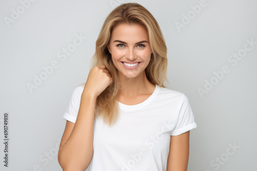Portrait of happy young woman in white t-shirt, isolated on grey background