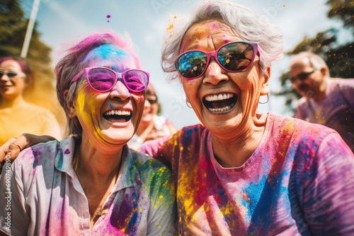Happy active senior friends with colorful powder on their faces and clothes looking at camera.
