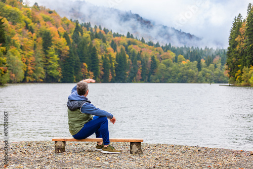 Man admiring the landscape by a mountain lake photo