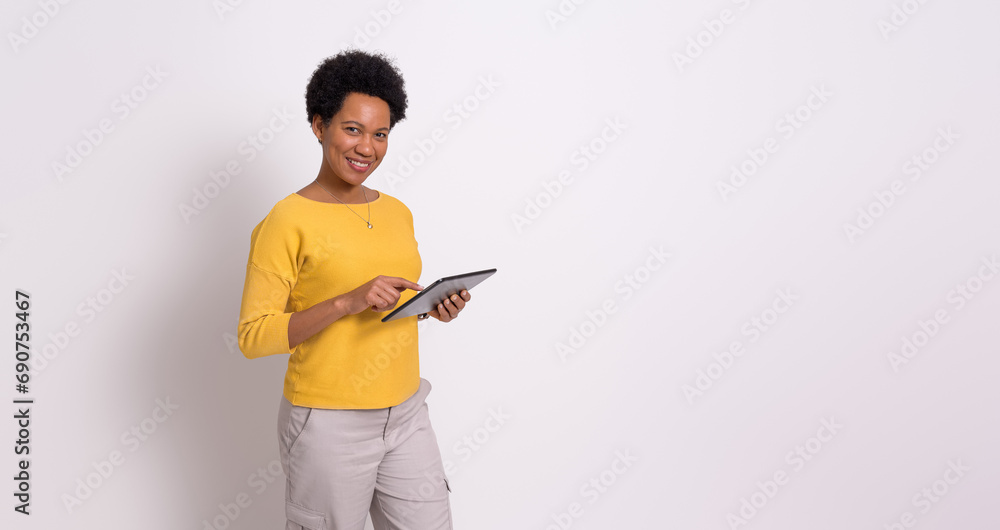 Confident female professional working on digital tablet while standing isolated on white background Confident female professional working on digital tablet while standing isolated on white background