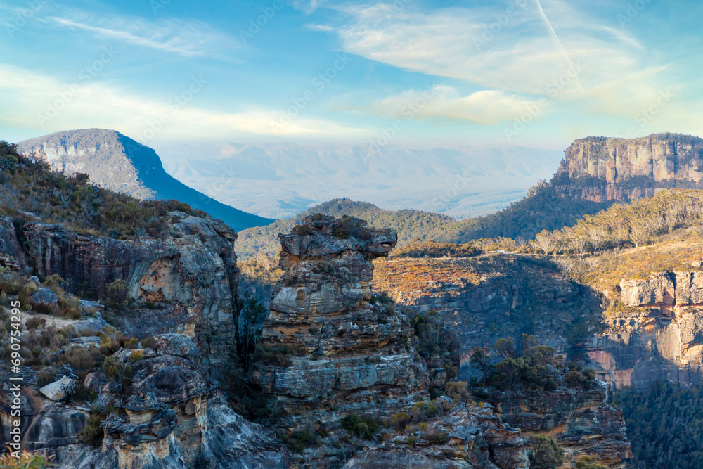 Photograph of the rugged and rocky cliff face of mountains the Megalong Valley in the Blue Mountains in New South Wales in Australia Photograph of the rugged and rocky cliff face of mountains the Megalong Valley in the Blue Mountains in New South Wales in Australia