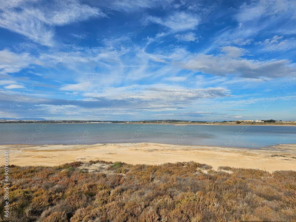 Horizon and mountains in the distance. View of the lagoon in Spain. Blue sky and clouds. Horizon and mountains in the distance. View of the lagoon in Spain. Blue sky and clouds.