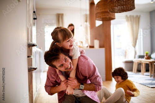 Happy young dad having fun with his kids on the floor at home photo
