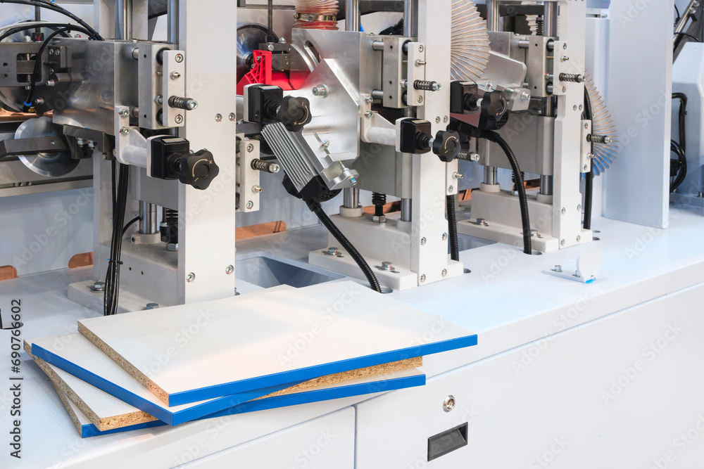 Wood boards on a woodworking machine in a modern furniture factory, woodworking industrial concept background Wood boards on a woodworking machine in a modern furniture factory, woodworking industrial concept background