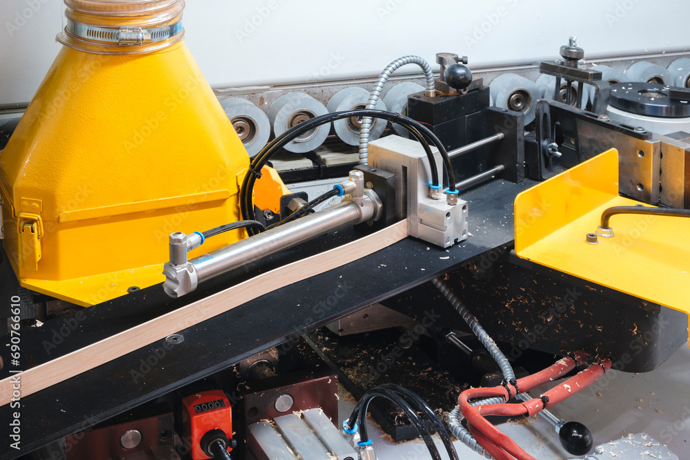 Wood boards on a woodworking machine in a modern furniture factory, woodworking industrial concept background Wood boards on a woodworking machine in a modern furniture factory, woodworking industrial concept background