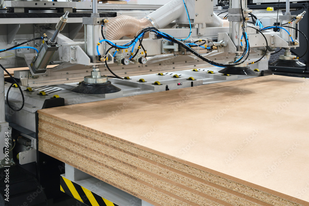 Wood boards on a woodworking machine in a modern furniture factory, woodworking industrial concept background