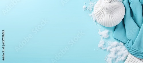 Suitcase with warm clothes on light blue background flat lay Winter vacation. Copyspace image. Header for website template photo